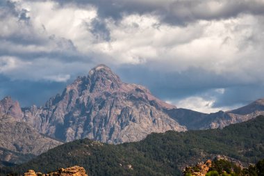 Orta Korsika 'daki Paglia Orba dağının kayalık zirvesi karanlık fırtınalı gökyüzünün altında