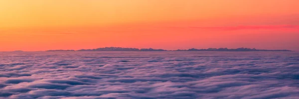 夕暮れ時にコルシカ島から見た雲の反転の上に現れるフランスとイタリアのアルプスのパノラマビュー — ストック写真
