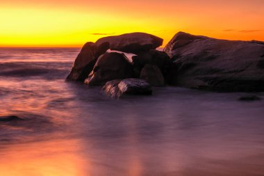Sahilde gün batımı ve Korsika 'nın Balagne bölgesindeki Algajola yakınlarındaki Aregno Plage' da kayalık.