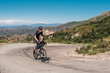 Speloncato, Korsika, Fransa - 7 Haziran 2022: Stéphane Lombard Speloncato köyü üzerindeki 1100 metre Col de Battaglia 'yı geçerek 2022 Bisikletçi Korsika yarışının lideri oldu. Bisikletçi Korsika, her yıl düzenlenen 1000km 'lik bir dayanıklılık bisiklet etkinliğidir.