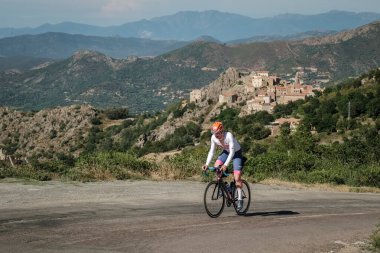 Speloncato, Korsika, Fransa - 7 Haziran 2022: Maximilien Couvreur, 750 km 'yi tamamladıktan sonra Speloncato köyü üzerindeki 1100 metre Col de Battaglia ile kapışırken 2022 Bikingman Korsika yarışına katılmıştır. Bisikletçi Korsika yıllık 1000km 'lik bir endur.