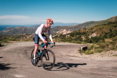 Speloncato, Korsika, Fransa - 7 Haziran 2022: Maximilien Couvreur, 750 km 'yi tamamladıktan sonra Speloncato köyü üzerindeki 1100 metre Col de Battaglia ile kapışırken 2022 Bikingman Korsika yarışına katılmıştır. Bisikletçi Korsika yıllık 1000km 'lik bir endur.