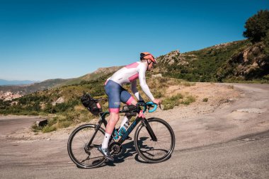 Speloncato, Korsika, Fransa - 7 Haziran 2022: Maximilien Couvreur, 750 km 'yi tamamladıktan sonra Speloncato köyü üzerindeki 1100 metre Col de Battaglia ile kapışırken 2022 Bikingman Korsika yarışına katılmıştır. Bisikletçi Korsika yıllık 1000km 'lik bir endur.