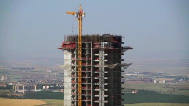 Cinematic 8K 7680x4320 4320p 60p.Cranes and construction workers working at a major.Builders on building site.Transporting wall molds at skyscraper.Concrete and iron combination.Yellow colored crane carrying material.Casting floor in industrial
