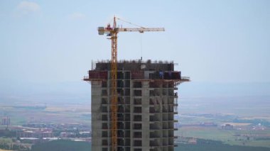 Cinematic 8K 7680x4320 4320p 60p.Cranes and construction workers working at a major.Builders on building site.Transporting wall molds at skyscraper.Concrete and iron combination.Yellow colored crane carrying material.Casting floor in industrial