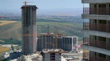 Cinematic 8K 7680x4320.Cranes and construction workers working at a major.Builders on building site.Transporting wall molds at skyscraper.Concrete and iron combination.Yellow colored crane carrying material.Casting reinforcing bar floor in industrial