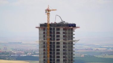 Cinematic 8K 7680x4320 4320p 60p.Cranes and construction workers working at a major.Builders on building site.Transporting wall molds at skyscraper.Concrete and iron combination.Crane carrying material.Casting reinforcing bar floor in industrial