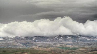 8K 7680x4320 4320p.First snow on standard hill in winter.Thick storm clouds in dark and white color.Time lapse view of geography in continental cold climate.Spectacular magnificent HDR landscape.