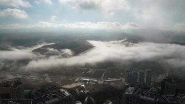 8K 7680X4320 4320p.Fog that covers the apartment buildings in the city is falling apart. Overcast layer. Freedom liberty and roominess spaciousness.Sea of fog is formed from stratus. Above the clouds.