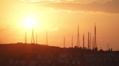 8K 7680X4320 4320p.Sunset behind high antennas towers.Iron and steel high antenna building.TV GSM transmitter antenna group in city.Time lapse footage.Red and orange color.background landscape view.