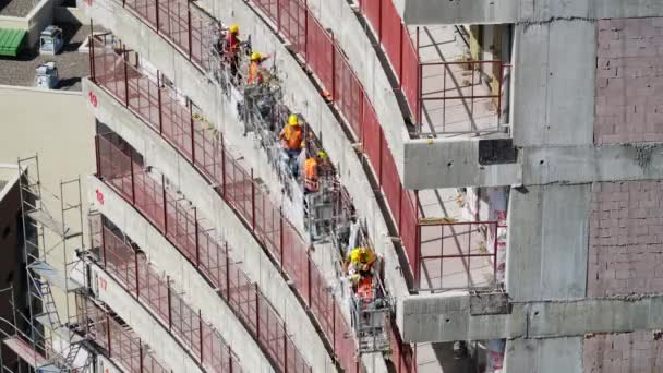 7680X4320 4320P 超高層ビルの一時停止プラットフォーム上の建設労働者 建設現場の吊りクレードルで働くことは 建設時の家の断熱材の壁を断熱します 足場の専門建設労働者 — ストック動画