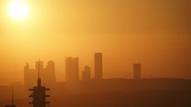 8K 4320p 7680x4320.Cloudless sunset through city skyscrapers.Time lapse clear and clean sky.High rise buildings in a new and modern residential area.Silhouette of buildings.Yellow orange and red color tone.Cinematic footage afternoon new day start