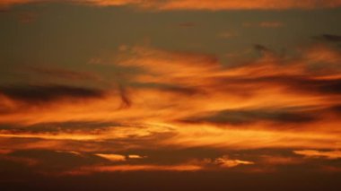 Cinematic 8K 7680x4320.Sunset time lapse footage.Evening and night is approaching.Sunbeams at background.The end, finish, final scene. Sundown through the dark clouds.Cloud is black color thin long lines.Novaya zemlya effect is a polar mirage
