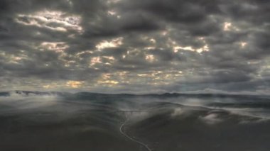 8K 7680x4320 4320p.Sunbeams among dark clouds after storm.Low hills in treeless terrestrial geography.Time lapse video of gloomy and depressing weather.Autumn and winter climate in nature.