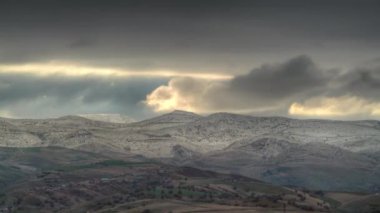 8K 7680x4320 4320p.First snow on standard hills and village houses in winter.Cute little village houses on the hillside.Cold and humid air in continental climate.Time lapse footage of clouds moving with thermal air flow.