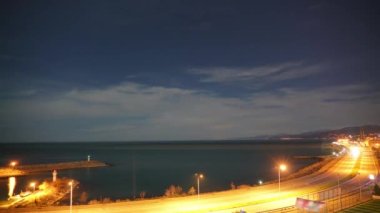 8K 7680X4320 4320p.Highway and harbor lights by the sea at night.Lights of lighthouses in the night fishing port at sea.A lighthouse is a tower, building, or other type of structure designed to emit light from a system of lamps