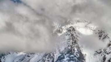 8K 7680X4320 4320p HDR.Imposing high altitude snowy mountain peaks behind the clouds.Weather in mountainous continental climate.Mount higher terrain geography nature slope ridge peak summit snow snows gorgeous spectacular wonderful best beautiful