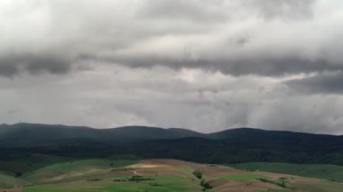 8K 7680X4320 4320p. seyrek ormanlık ve gür tepelerdeki köy evleri. Kırsal alanlara yaklaşan fırtına bulutları. Bozkır çalı çalı çalı çalı çalı çalısı zamanı hızlandırılmış hava akımı sinematik manzara bulutları doğa bulutları. 