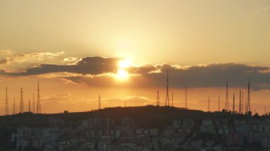 8K 7680X4320 p.p. Yüksek antenlerin arkasında günbatımı. Anten kulesi teknolojisi güneşli bir gün inşa ediyor. Son gün, bulutlar hızlanıyor. 