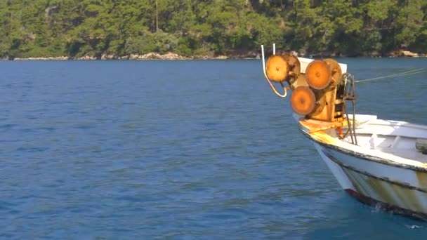 小さなプラスチック製のフロートに接続されたフロートラインを持つナイロン釣りネット 海に行く古いボートで釣りネットリール 背景に青い海と小さな釣りトロールにネットスプール機構のクローズ — ストック動画