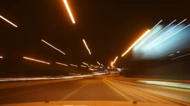 8K 7680x4320. Gece ışıkları ve şehir yollarındaki trafik. Hat kepenkleri gece karanlığında hareket ediyor. Araç farları. Bokeh etkisi ve şehir ışıkları..