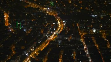 8K 7680X4320.Deniz yoluyla gece kenti. Yoğun bir kasaba sokaklarının zaman aşımı. Trafikten gelen ışık çizgileri ve parlak binalar. Parlak renkli ışıklar..