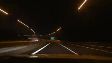 8K 7680x4320. Gece ışıkları ve şehir yollarındaki trafik. Hat kepenkleri gece karanlığında hareket ediyor. Araç farları. Bokeh etkisi ve şehir ışıkları..