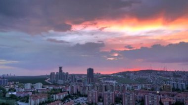 8K 7680X4320 p.20 Akşam üzeri gökyüzü kızıl günbatımına doğru. Öğleden sonra gökdelenler arasında. Yeni Lahore Pakistanındaki zaman atlamalı binalar.