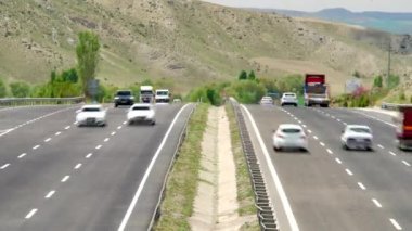 8K 7680X4320.Standart karayolu trafiği. Üç şeritli yol. Ağır trafik. Şehir kırsalının yakınındaki ana yollarda otobüs ve tanker kamyonunun üstten görüntüsü.