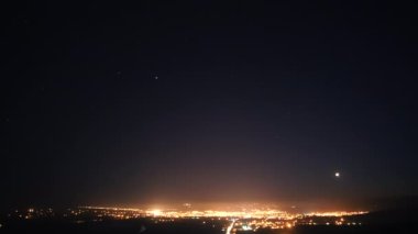 8K 7680X4320 Gece Yıldızlı gökyüzü altında şehir ışıkları. Yerleşim ışıkları üzerinde yıldızlar. Gece yıldızlı gökyüzü ve köy ışıkları ön planda. Gerçek ışık yoğunluğundaki en iyi yıldızlar..