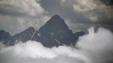 8K 7680X4320 4320. Bulutların üzerindeki Rocky keskin dağ zirvesi. Dağlık yüksek arazi coğrafyası topoğrafya topoğrafyası, yamaçlı tepe tepeleri zirvesi.