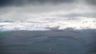 8K 7680x4320. Ağaçsız tepelerde ince kar tabakası. Standart bozkır arazisi. Çorak çalılık, seyrek ağaçlı bozkır tepeleri..