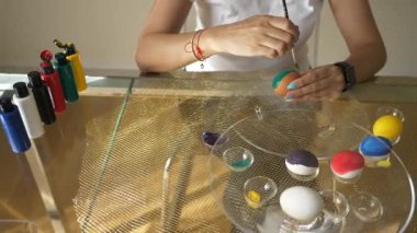 8K 7680x4320. Paskalya yumurtası boyayan kadın. Doğunun kültürel sembolü. Geleneksel paskal yumurta boyaları. Folklorik figür ve Hıristiyan kültürünün sembolü. Geleneksel bahar süslemeleri ve süslemeleri..