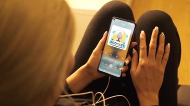 4K Kız telefonundan podcast dinliyor. Antisosyal ve depresif yeni nesil genç. Toplumdan dışlanmış içe dönük genç bir kız. Müzik dinleyen bir kadın. Genç sarışın gece lambası..