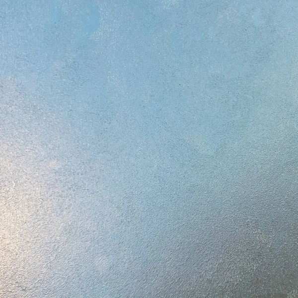 Παγωμένο γυαλί με την έναρξη του κρύου καιρού. Θέα μέσα από το στρώμα πάγου του γαλάζιου ουρανού. — Φωτογραφία Αρχείου