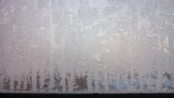 Froststruktur på fönsterglaset på vintern. Iskristaller i vinterblått och rosa. — Stockfoto