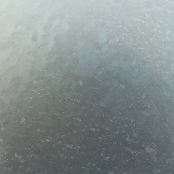 Vidrio congelado con el inicio del clima frío. Vista a través de una capa de hielo al cielo gris. — Foto de Stock