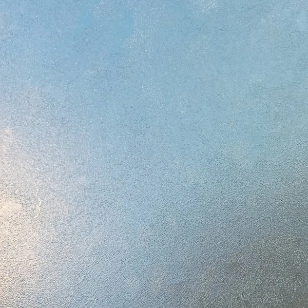 Παγωμένο γυαλί με την έναρξη του κρύου καιρού. Θέα μέσα από το στρώμα πάγου του γαλάζιου ουρανού. — Φωτογραφία Αρχείου