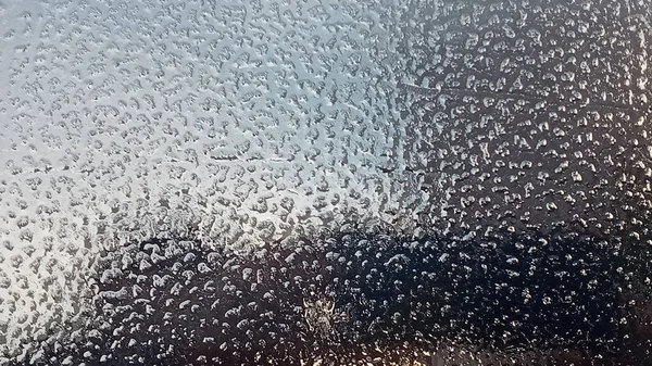 Fryst vindruta. Granulat struktur genomskinlig is. Himlen skiner igenom. Abstrakt isbakgrund. — Stockfoto