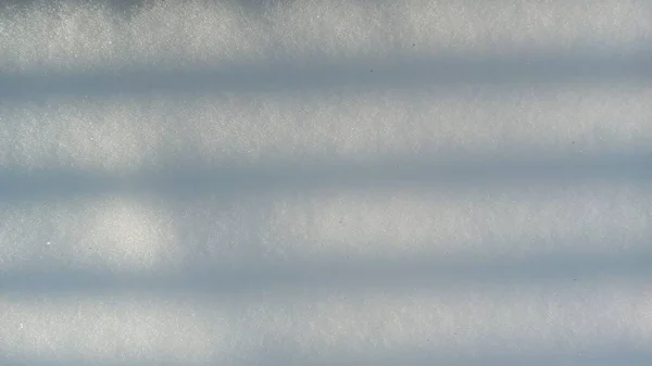 Cień w postaci prostych linii na śnieżnej powierzchni, abstrakcyjne tło. — Zdjęcie stockowe
