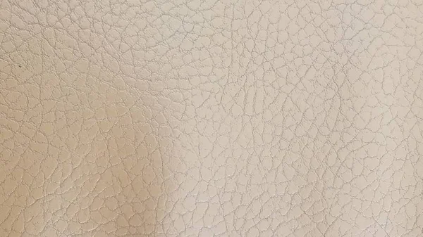 Lesklé béžové kožené pozadí zblízka. Béžová lesklá textura z umělé kůže. — Stock fotografie