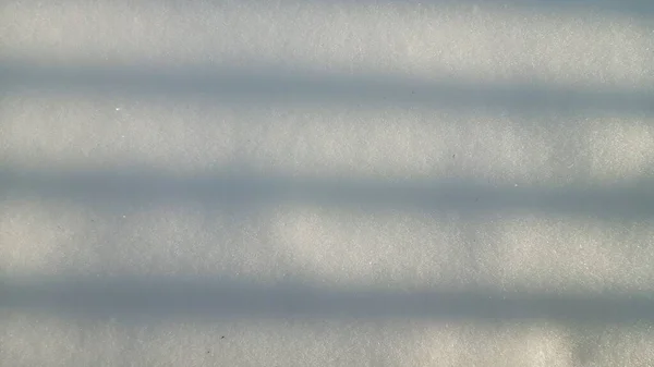 Σκιά με τη μορφή ευθειών γραμμών σε χιονισμένη επιφάνεια, αφηρημένο φόντο. — Φωτογραφία Αρχείου