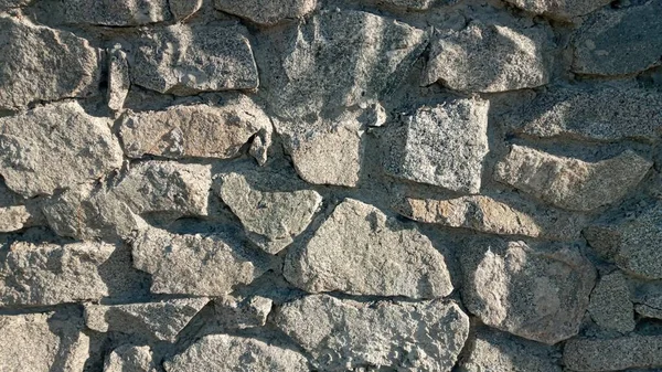 Deel van een stenen muur, voor achtergrond of textuur. Textuur van een stenen muur. Stenen muur als achtergrond of textuur. — Stockfoto