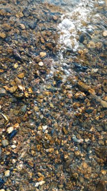 Sahilde düzgün yuvarlak çakıl taşlarının görünümü kadar kapatın.