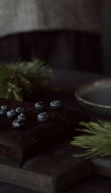 Tahta arka planda fındıklı ve yaban mersinli çikolatalı pasta.