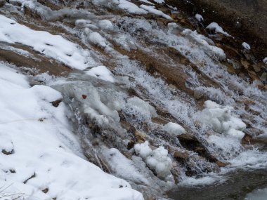 Kışın mavi ve beyaz renkli buzlu donmuş bir şelale. Kış arkaplanı.