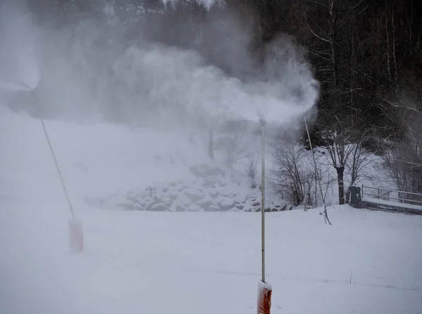 冬季山上的雪炮 白雪公主喷出人造冰晶造雪的机器长长的滑雪电梯线和工作的雪炮的美丽景色 — 图库照片