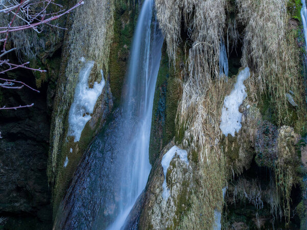 a closeup shot of a waterfall surrounded by the river