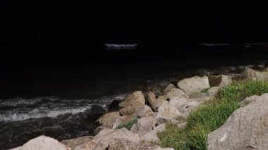 Dalgalar kıyıya vuruyor. Akşamları taşlı bir plaja yaklaşıyoruz.