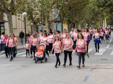 22 Ekim 2022 'de Huesca şehrinde göğüs kanserine karşı yarışan koşucular göğüs kanserine katılan mutlu kadınların park portresinde finiş çizgisini geçerek tezahürat yaptılar.